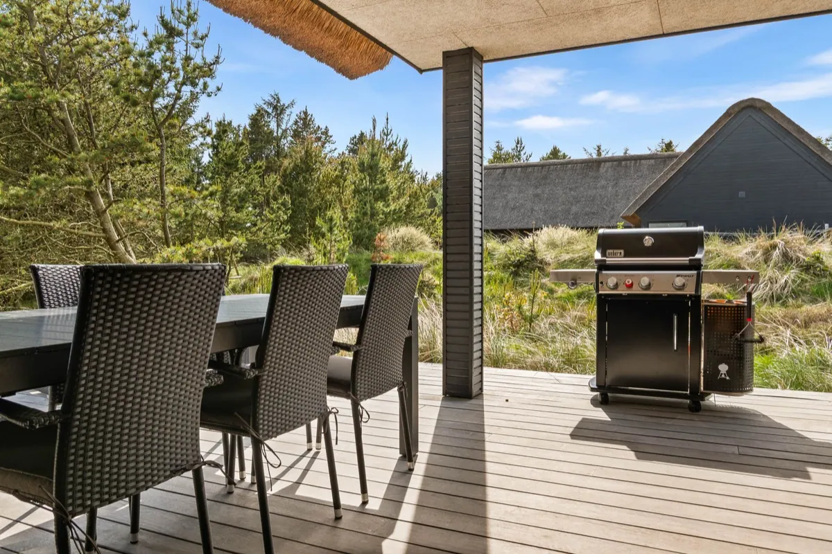 Overdækket terrasse ved stråtækt feriebolig i Blåvand