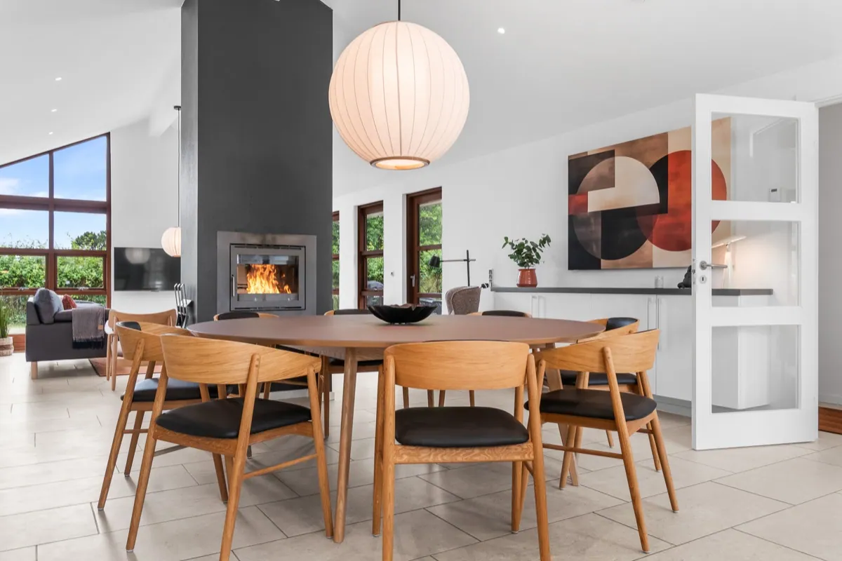 Lys spisestue med pejs og dansk møbeldesign